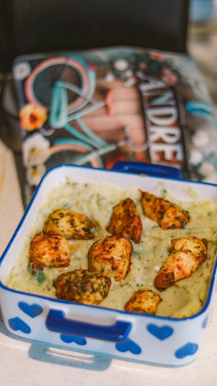 Delicious oven-baked chicken served on a creamy spinach dip in a heart-designed dish.